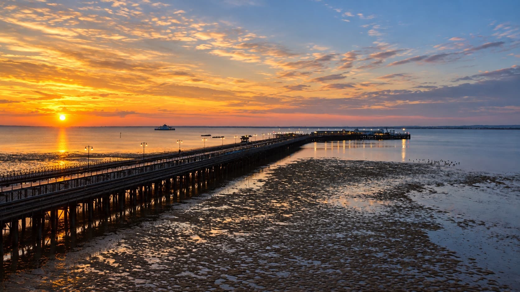 Sunset over the Solent from Ryde, with the pier lights and the low-tide sands